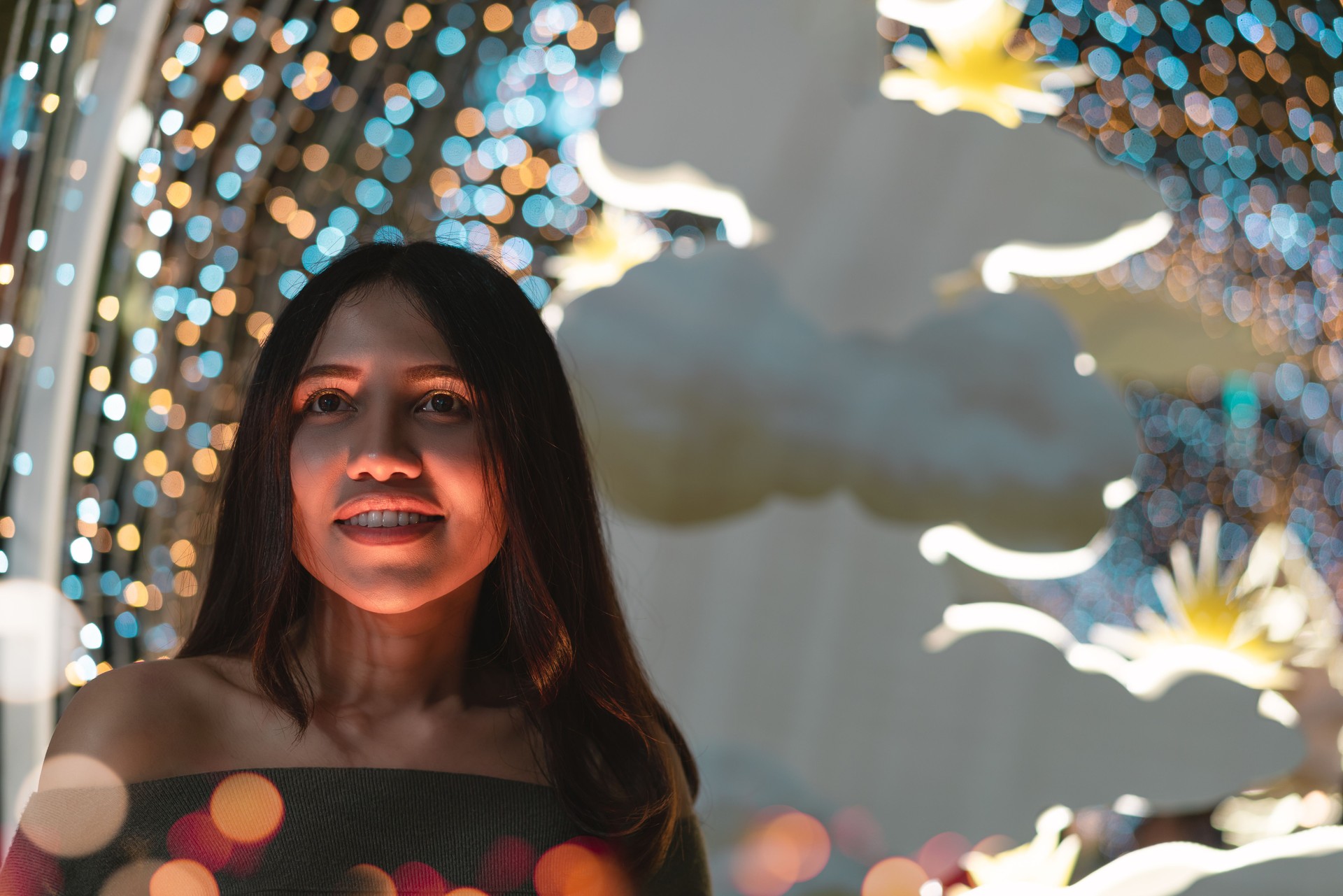 Diverse Asian party girl arriving at nightclub with colourful bokeh lights