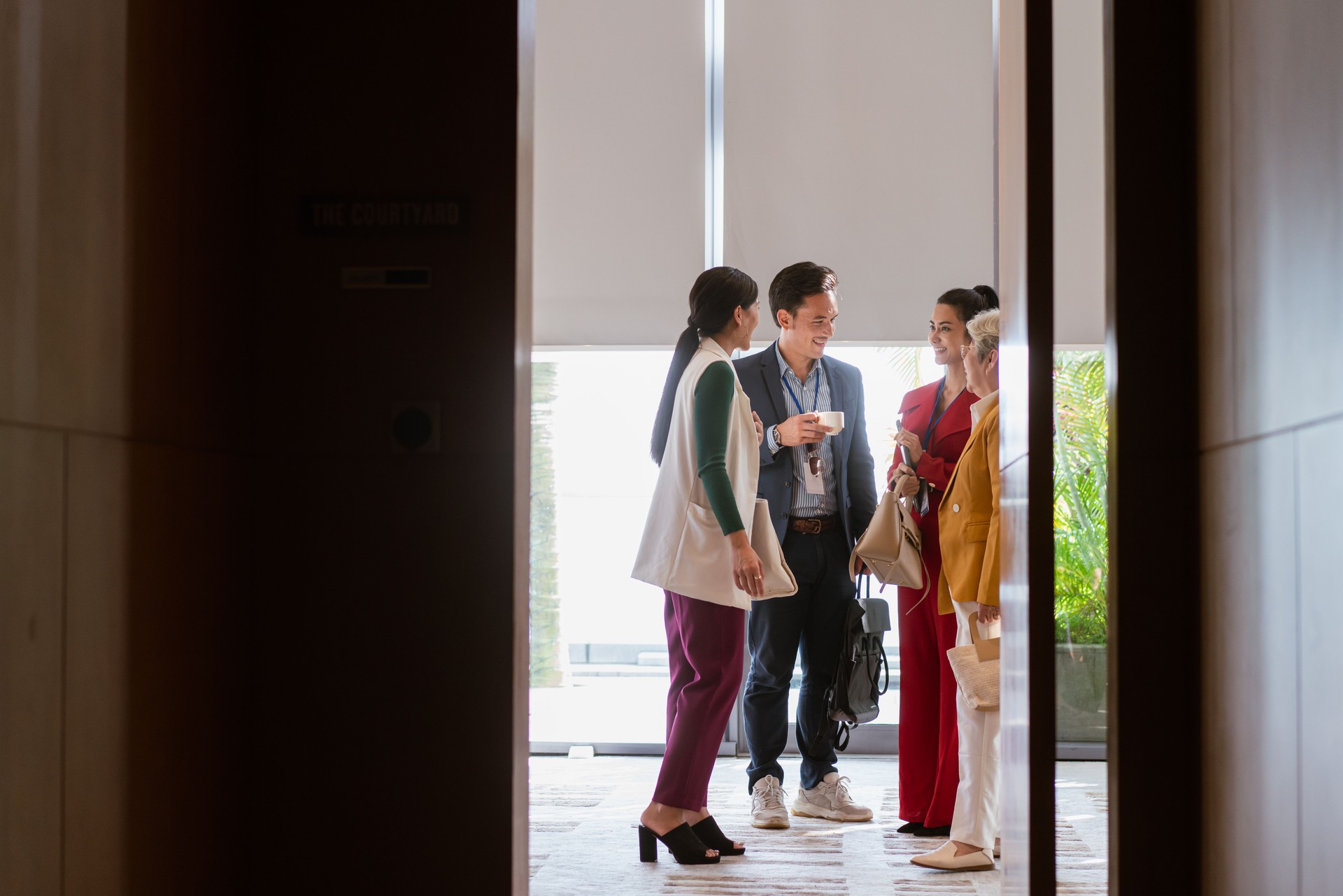 Group of business professionals congregate and network during a conference break